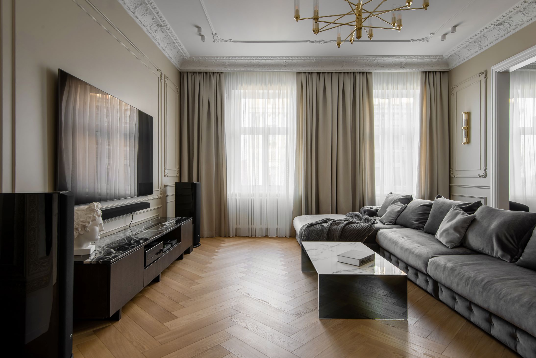 Klasisks dzīvoklis Rīgas centrā - dzīvojamā istaba ar pelēku dīvānu un televizoru
